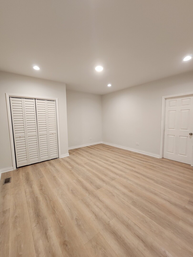 8900 South Normal Avenue Chicago, IL 60620 - Photo 9 of 28 an empty room with wooden floor and natural light