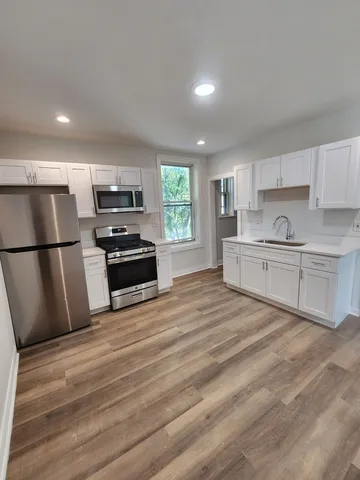 a kitchen with stainless steel appliances a refrigerator sink and microwave