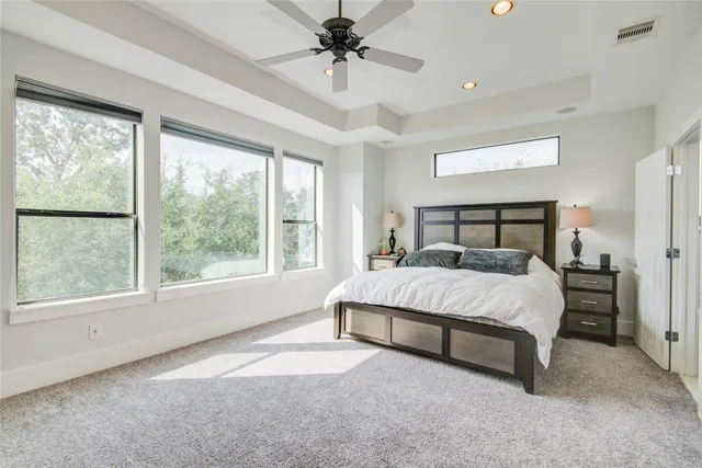 a bed sitting in a spacious bedroom next to a window