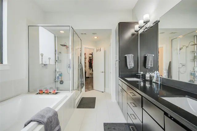 a spacious bathroom with a sink double vanity granite tub shower and mirror