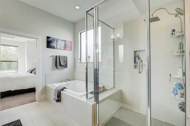 a bathroom with a tub shower and hallway view