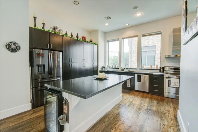 a kitchen with stainless steel appliances granite countertop a sink a stove and a refrigerator