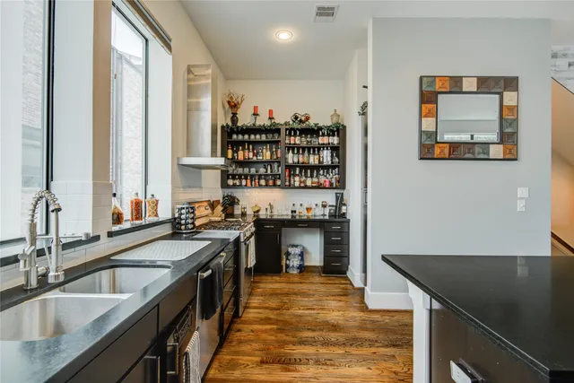 a kitchen with stainless steel appliances granite countertop a stove a sink and a refrigerator