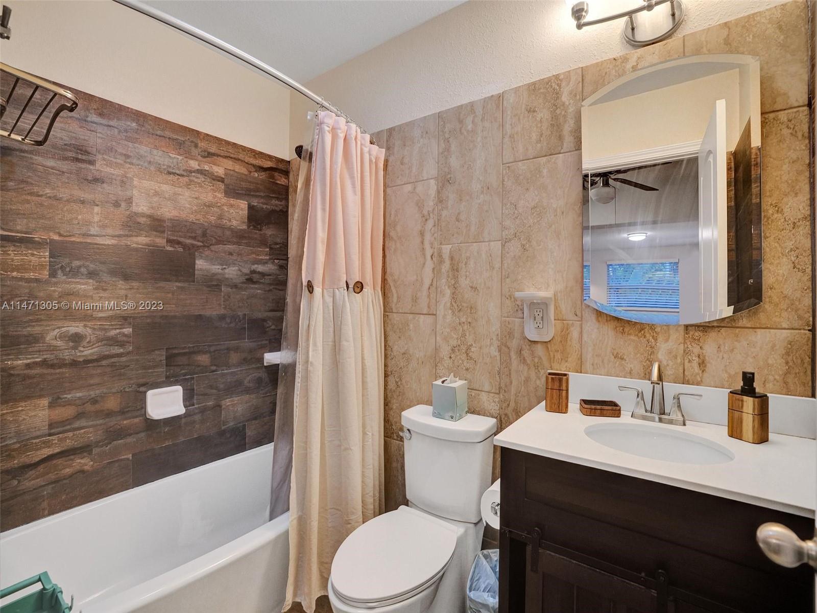 2028 South Conference Drive Boca Raton, FL 33486 - Photo 29 of 62 a bathroom with a sink a toilet a mirror a bathtub and shower
