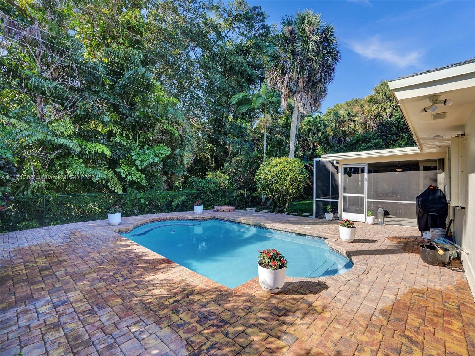 2028 South Conference Drive Boca Raton, FL 33486 - Photo 36 of 62 a view of a swimming pool with lawn chairs under an umbrella