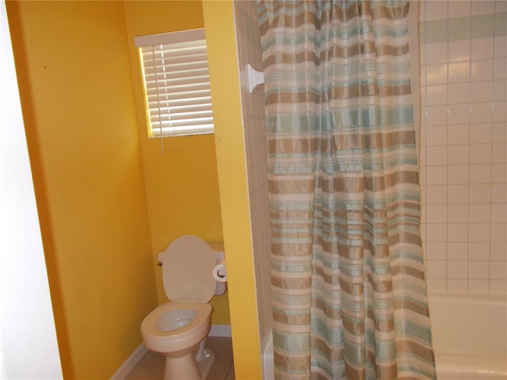 2880 Geneva Road Venice, FL 34293 - Photo 14 of 19 a bathroom with a toilet and a shower curtain