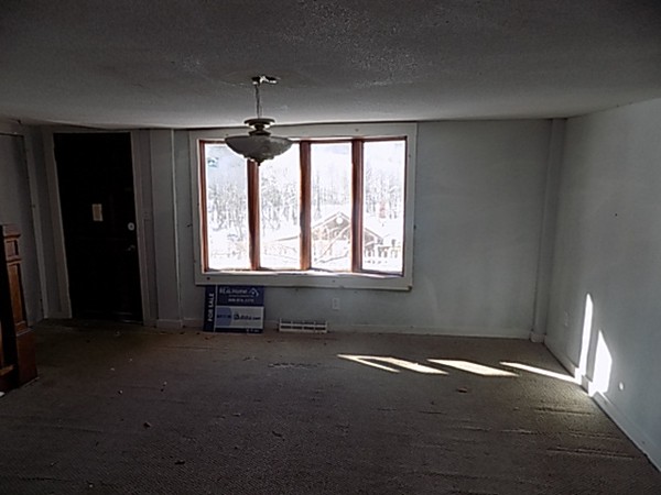 13 Basket Street Huntington, MA 01050 - Photo 3 of 18 en empty room with windows and chandelier