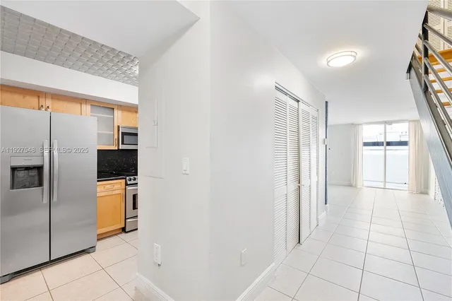 a view of a refrigerator in kitchen and a window