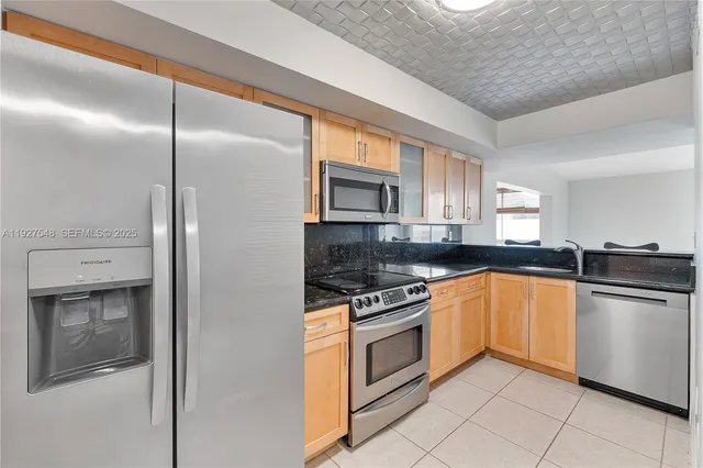 a kitchen with stainless steel appliances granite countertop a stove a sink and a refrigerator