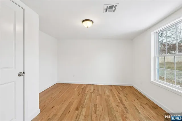 a view of a room with wooden floor and white walls