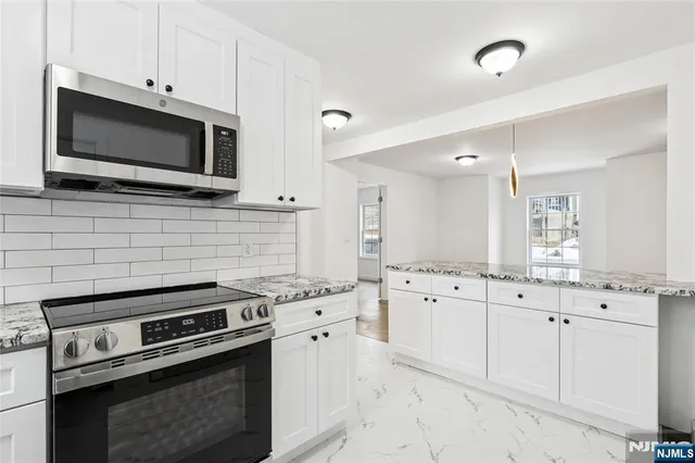 a kitchen with cabinets stainless steel appliances and a sink