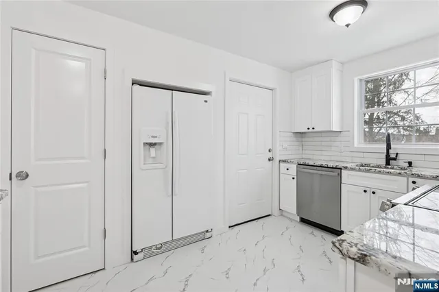 a kitchen with granite countertop white cabinets and white appliances