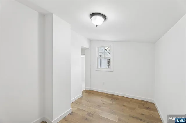 a view of a room with wooden floor and window