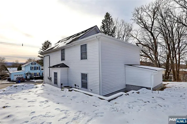a view of a house with a yard covered in snow