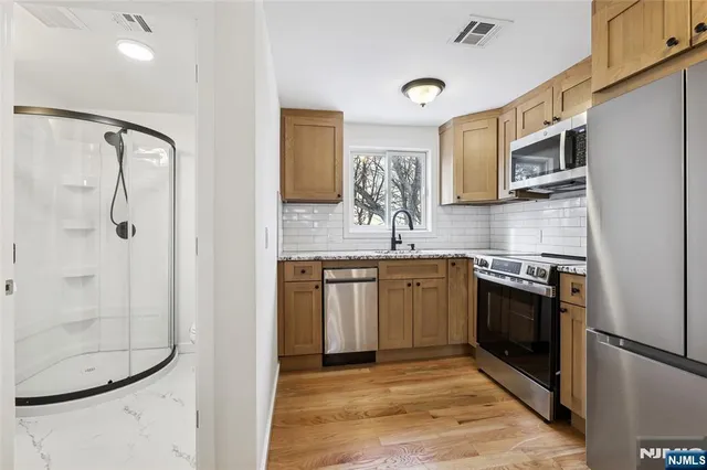 a kitchen with stainless steel appliances granite countertop a refrigerator and a sink