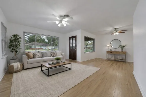 a living room with furniture and a wooden floor