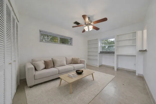 a living room with furniture and a ceiling fan