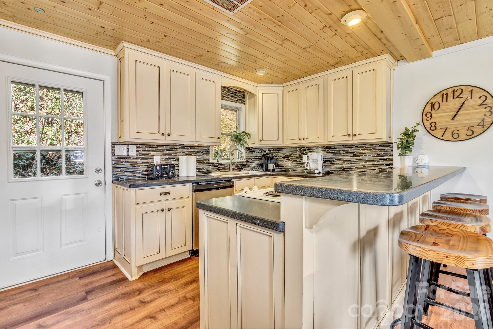 80 Hidden Falls Road Maggie Valley, NC 28751 - Photo 21 of 47 a kitchen with stainless steel appliances granite countertop a sink a stove a chimney a refrigerator and cabinets