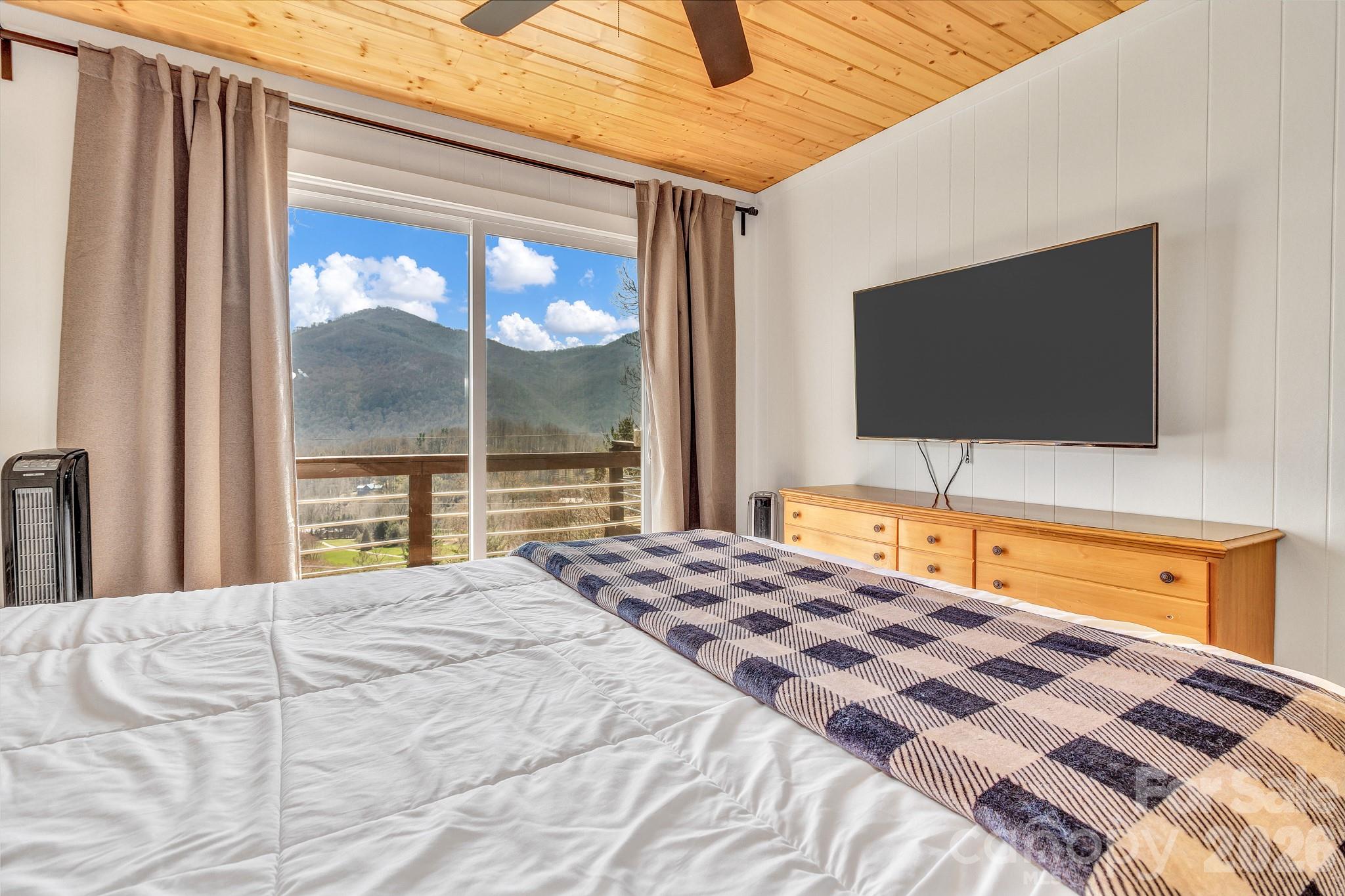 80 Hidden Falls Road Maggie Valley, NC 28751 - Photo 27 of 47 a bedroom with a bed and a flat screen tv
