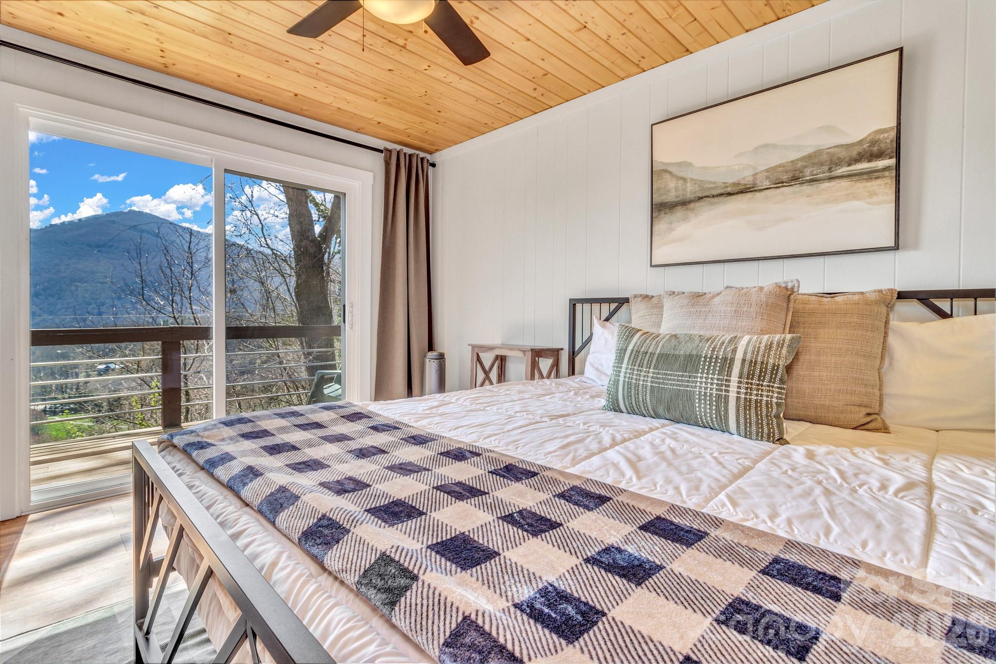 80 Hidden Falls Road Maggie Valley, NC 28751 - Photo 32 of 47 a bedroom with a bed and a painting on the wall