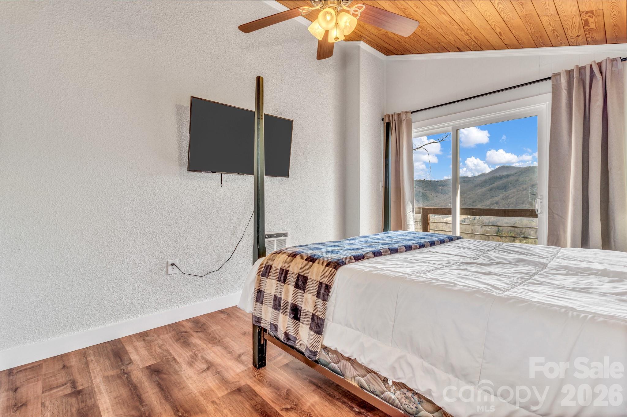 80 Hidden Falls Road Maggie Valley, NC 28751 - Photo 37 of 47 a bedroom with a bed and a flat tv screen on dresser