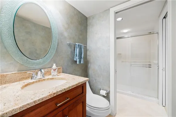 a bathroom with a toilet a sink and mirror