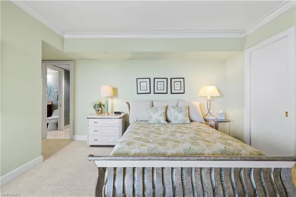 a bedroom with a bed and painting on the wall