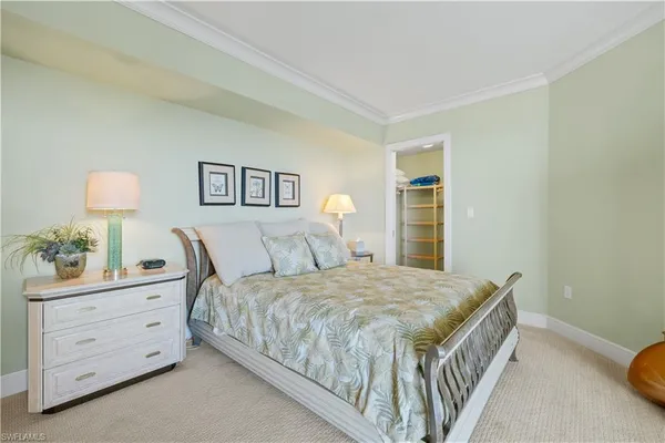 a bedroom with a large bed and a flat tv screen on dresser