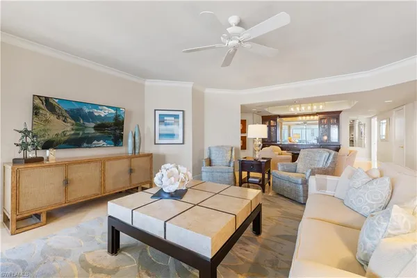 a living room with furniture a window and a flat screen tv