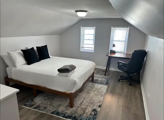 a bed sitting in a bedroom next to a window