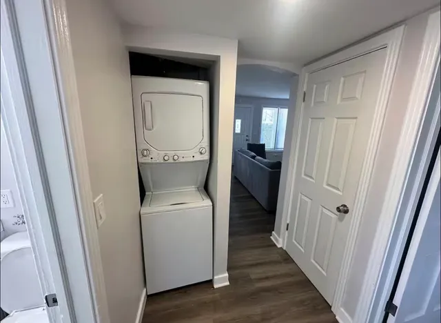 a utility room with wooden floor washer and dryer