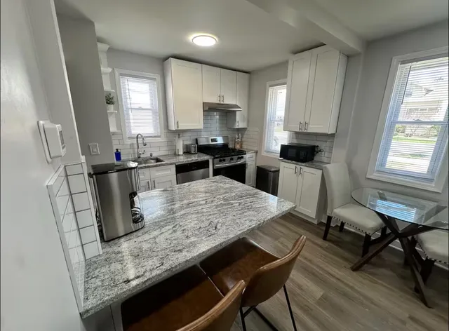 a kitchen with stainless steel appliances granite countertop sink stove top oven and microwave