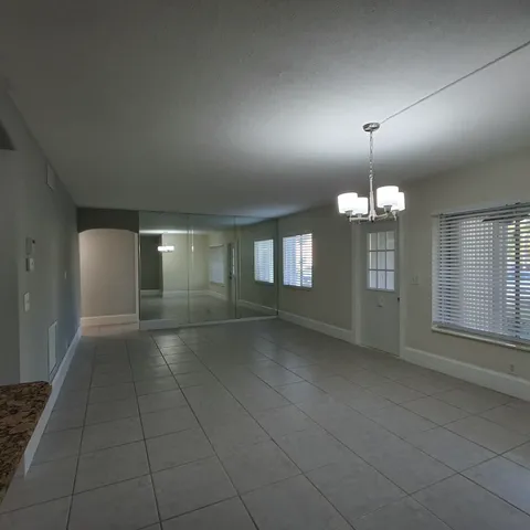 an empty room with fan and windows