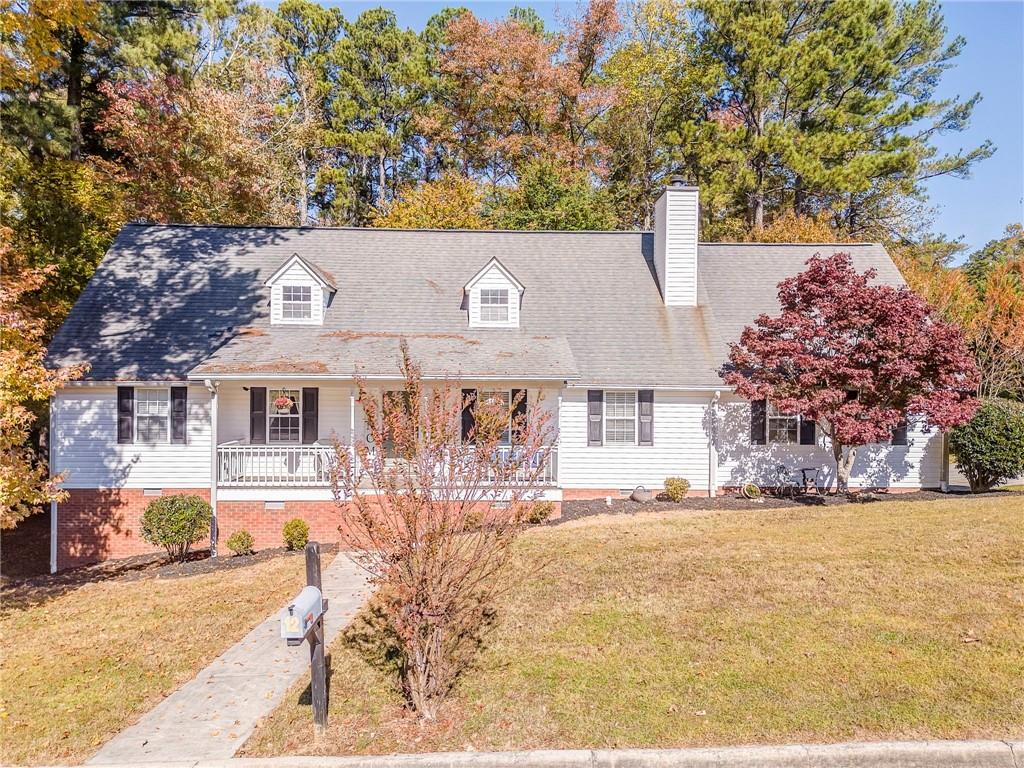 a front view of house with yard and trees in the background
