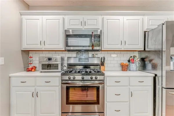 a kitchen with granite countertop appliances sink and cabinets