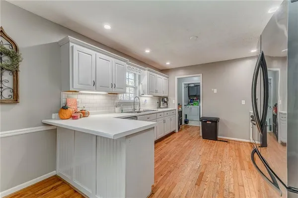 a kitchen with stainless steel appliances granite countertop a stove and white cabinets