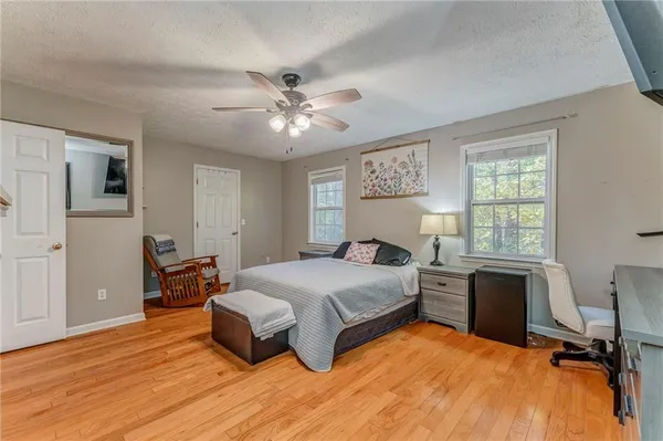 a spacious bedroom with a bed and a flat screen tv