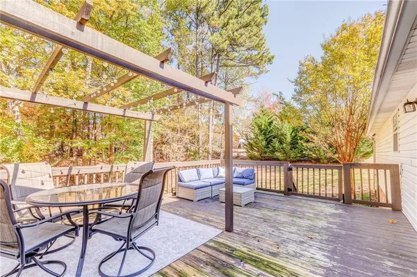 a balcony with wooden floor and outdoor seating