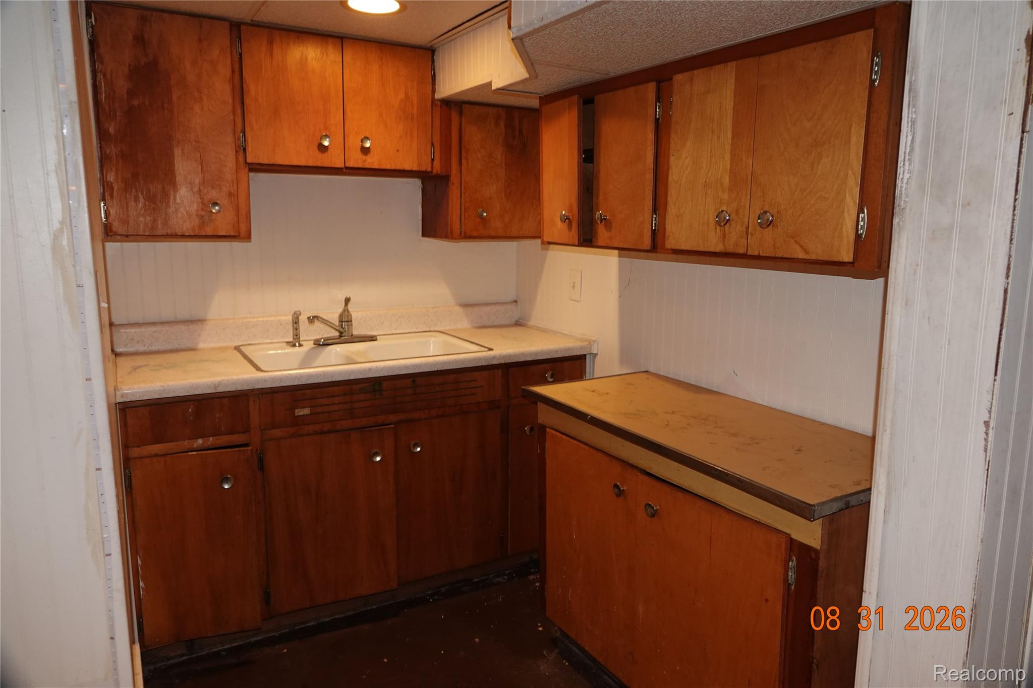 7654 Fielding Street Detroit, MI 48228 - Photo 19 of 23 Kitchen featuring wood cabinetry, a double basin sink, and white beadboard paneling