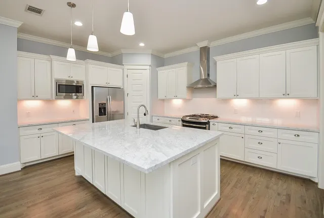 a kitchen with granite countertop white cabinets and white appliances