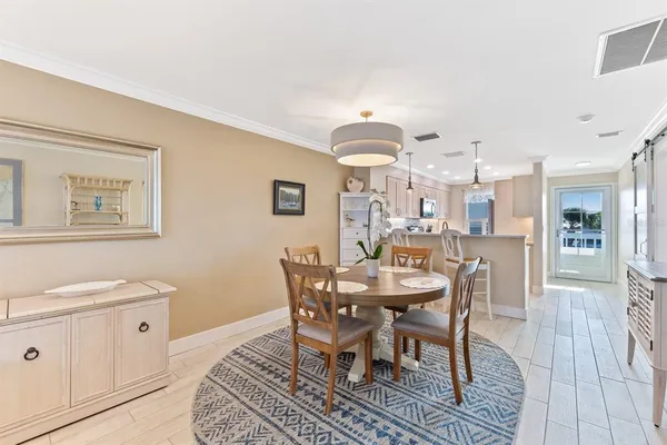 a kitchen with stainless steel appliances kitchen island granite countertop a table chairs refrigerator and sink