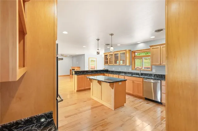 a large kitchen with stainless steel appliances granite countertop a stove a sink and a refrigerator