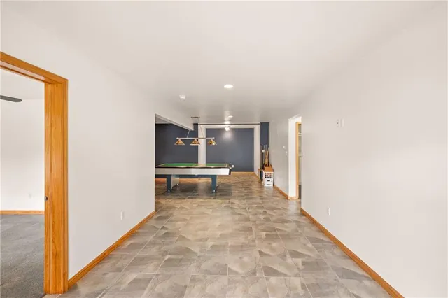 a view of a hallway with wooden floor and chair