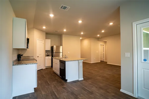 a kitchen with kitchen island sink stove and cabinets