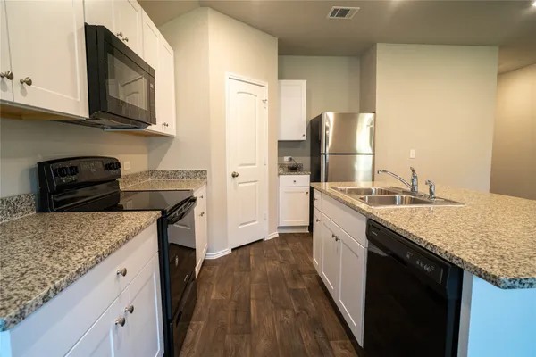 a kitchen with granite countertop stainless steel appliances and wooden cabinets