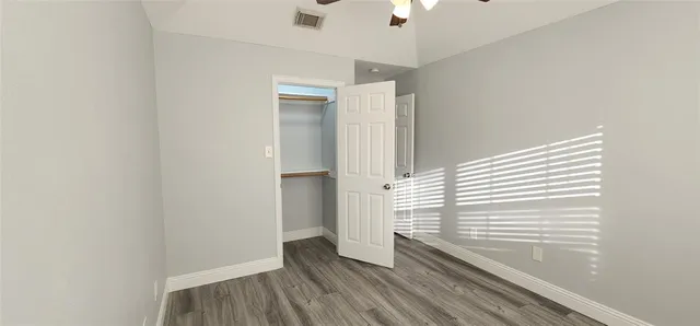 a view of an empty room with a window and a ceiling fan