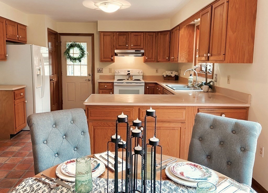 258 Old Warren Road Palmer, MA 01069 - Photo 8 of 24 a kitchen with stainless steel appliances a sink a stove a refrigerator cabinets and a dining table