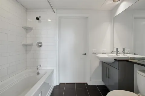 a bathroom with a bathtub sink mirror vanity and toilet