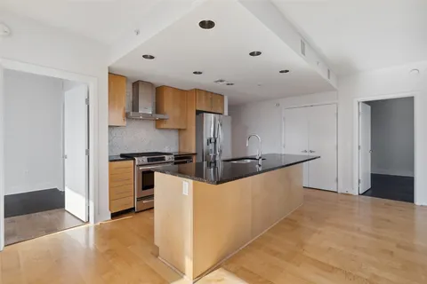 a large kitchen with stainless steel appliances a sink and a refrigerator