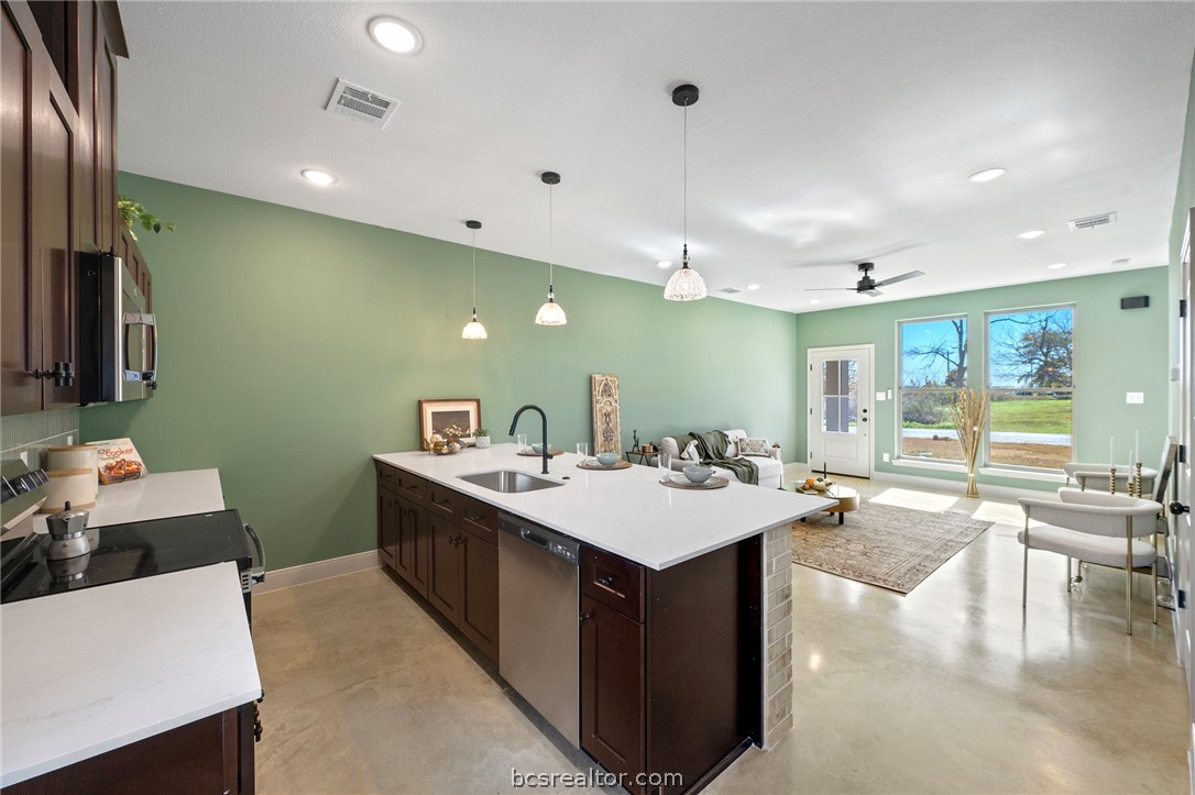 106 33rd Street West Bryan, TX 77803 - Photo 5 of 22 a large kitchen with kitchen island a sink a counter top space and stainless steel appliances